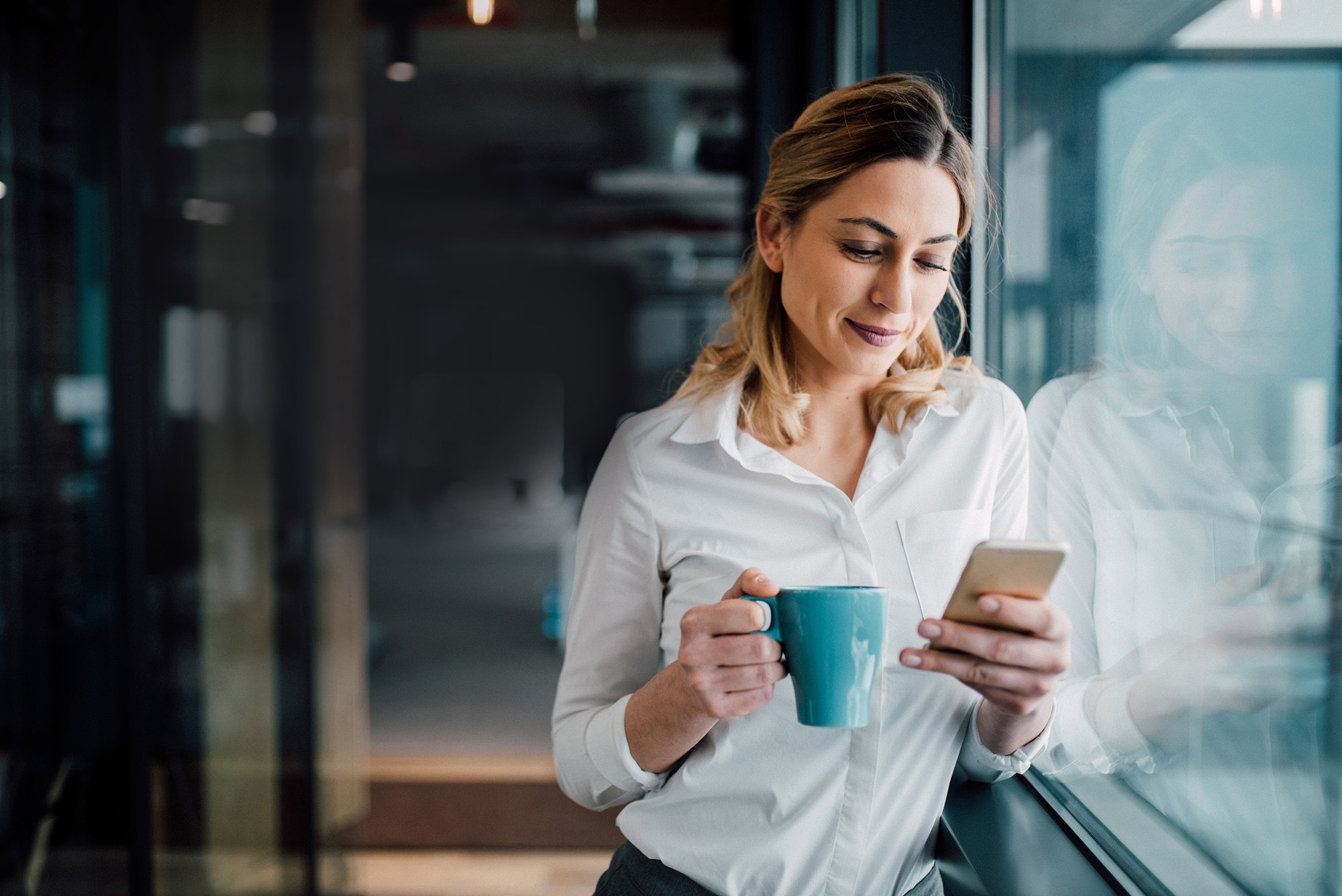 iStock-woman in office on phone with coffee